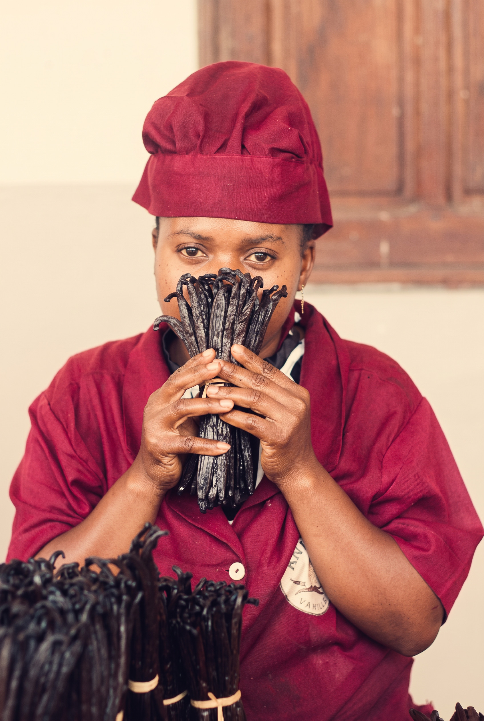 Brown Vine worker holding a bundle of vanilla beans